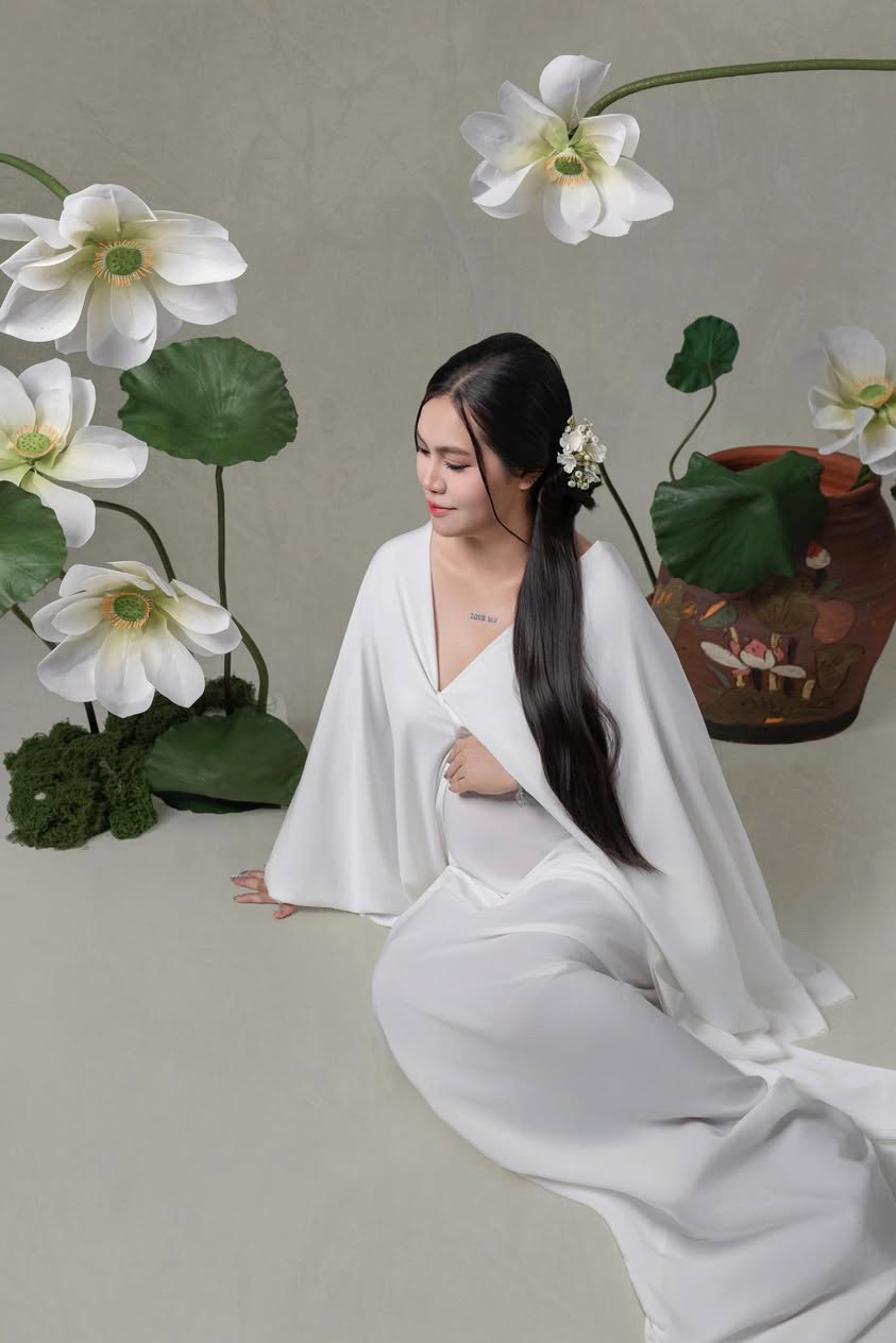 Mẹ bầu mặc trang phục trắng giữa bối cảnh hoa sen